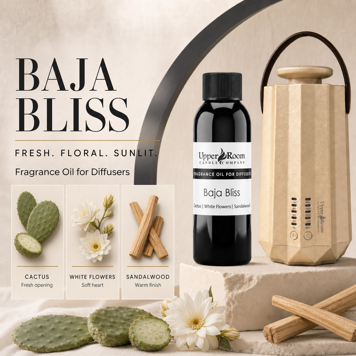 Baja Bliss fragrance oil for diffusers by Upper Room Candles Company, shown in a black bottle next to a beige geometric diffuser. The ad includes product imagery of cactus, white flowers, and sandalwood, with text reading 'BAJA BLISS' and 'FRESH.