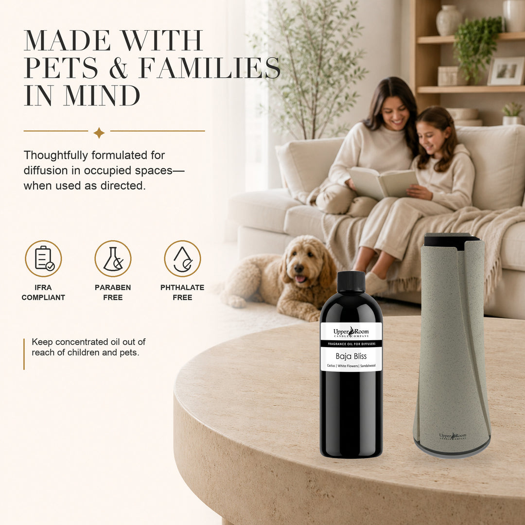 A pet and family and diffuser shown in a cozy living room scene alongside a round table, with a black bottle labeled 'Baja Bliss' and a tall gray diffuser. Text on the left highlights pet and family-friendly formulation.